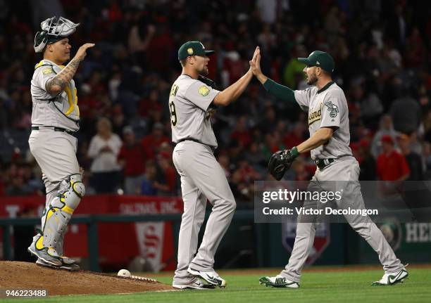 Catcher Bruce Maxwell, pitcher Blake Treinen and Matt Joyce of the Oakland Athletics celebrate after the MLB game against the Los Angeles Angels of...