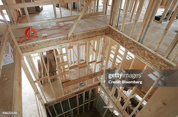 Stud-framed walls around an opening with a view through to the basement are seen in a new home under construction December 21 in Park Ridge,...