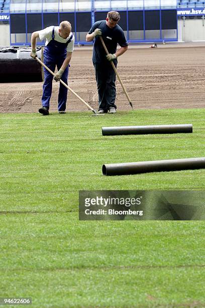 Workers lay new turf in the FIFA WM stadium in Hamburg, Germany, on Wednesday, May 17, 2006. Workers laid new grass before the start of the 2006...