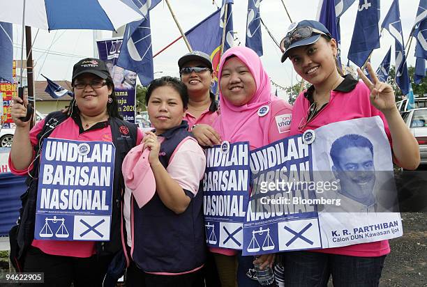 Supporters of the ruling Barisan Nasional Party cheer outside a polling station on voting day of the Malaysian by-elections in Ijok, Selangor,...