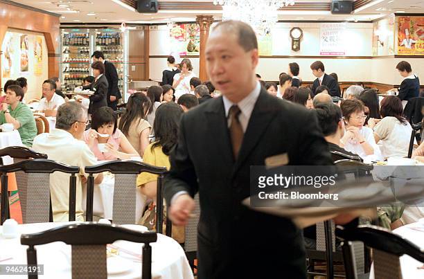 Server with a platter works at Victoria City Seafood Restaurant in the Wan Chai district of Hong Kong, China, on Sunday, June 17, 2007. The...