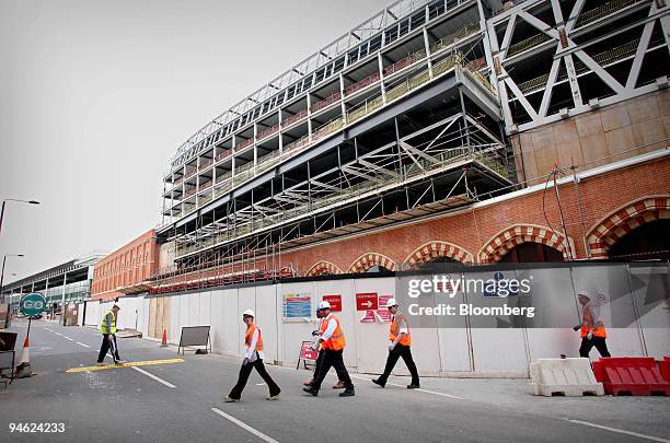 Construction workers walk outside the new concourse at the St. Pancras station development in north London, U.K., on Friday, Sept. 21, 2007. The...