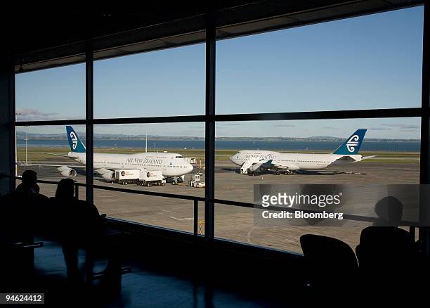 Travellers survey the Air New Zealand planes parked on the tarmac at Auckland International Airport, in Auckland, New Zealand, on Monday, June 18,...