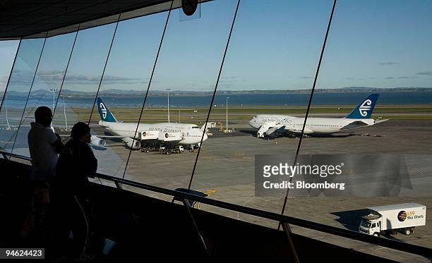 Travellers survey the Air New Zealand planes parked on the tarmac at Auckland International Airport, in Auckland, New Zealand, on Monday, June 18,...