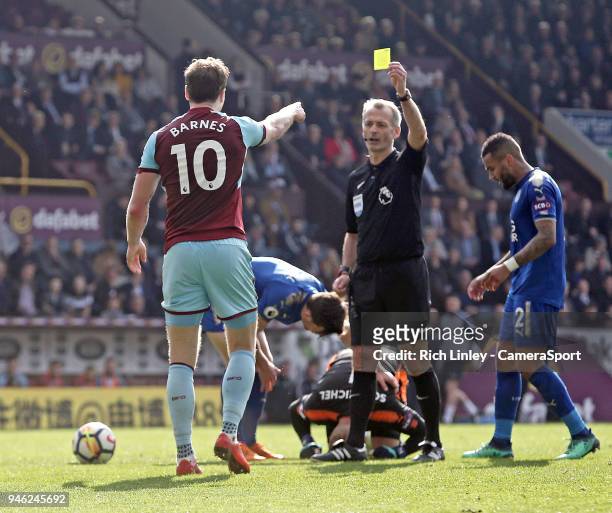 Burnley's Ashley Barnes is shown a yellow card by Referee Martin Atkinson for his challenge on Leicester City's Kasper Schmeichel during the Premier...