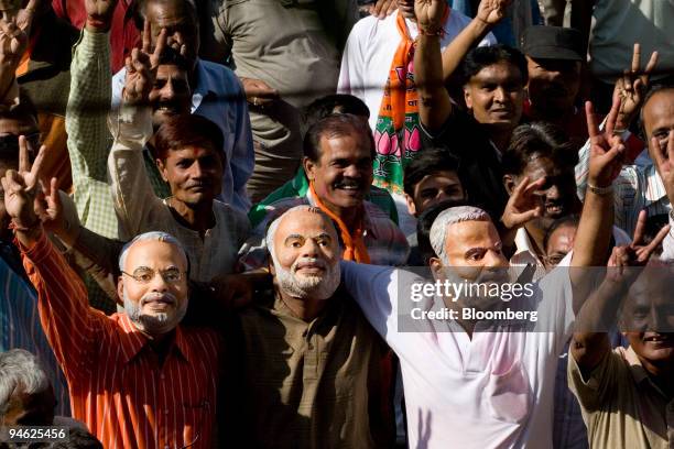 Supporters of the Hindu nationalist Bharatiya Janata Party wearing masks of Narendra Modi, chief minister of Gujarat State, show the victory sign as...