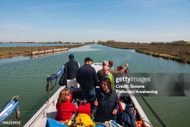 Tourists sail a canal on a boat of a fishing tour organized by Cooperativa San Marco in Burano on April 14, 2018 in Venice, Italy. At the beginning...