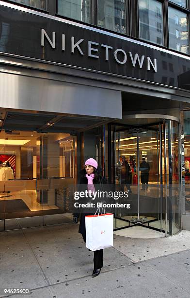 Nicole Erenburg exits Niketown with a Nike shopping bag in New York, U.S., on Tuesday, Dec. 18, 2007. Nike Inc., the world's largest athletic-shoe...