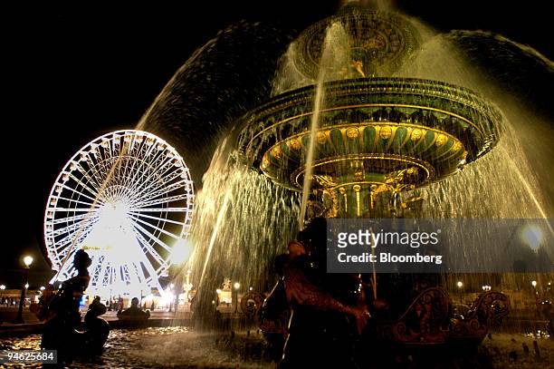 The lights on the Grand Roue shimmer as water showers out of a fountain at the Place de la Concorde in the west of Paris, France, on Friday, Sept....