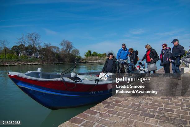 Tourists go in the boat of a tour of fishing tourism of 'Moeche' organized by Cooperativa San Marco in Burano on April 14, 2018 in Venice, Italy. At...