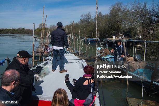Tourists attend a fishing tour of 'Moeche' organized by Cooperativa San Marco in Burano on April 14, 2018 in Venice, Italy. At the beginning of the...