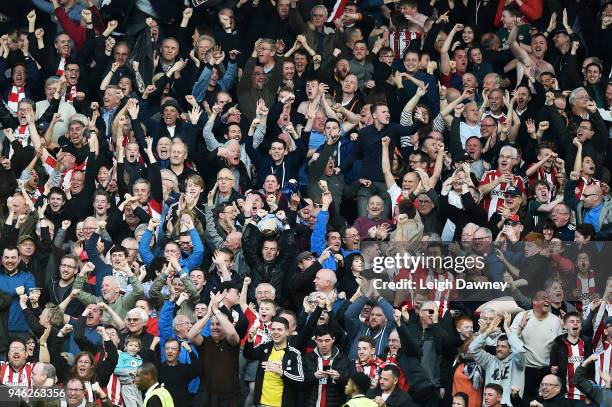 Brentford fans celebrate after their team scored the equalising goal during the Sky Bet Championship match between Fulham and Brentford at Craven...