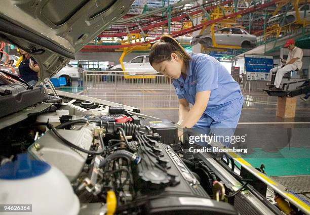 An employee works on a car on the production line at the Chana Motors Co. Ltd., factory in Chongqing, China, on Friday, June 15, 2007. China's...