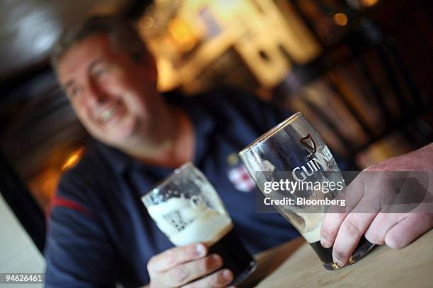 Customers drink Guinness beer at the Bell public house in Wendens Ambo, Essex, UK, Wednesday, Aug. 29, 2007. Diageo Plc, the world's biggest liquor...