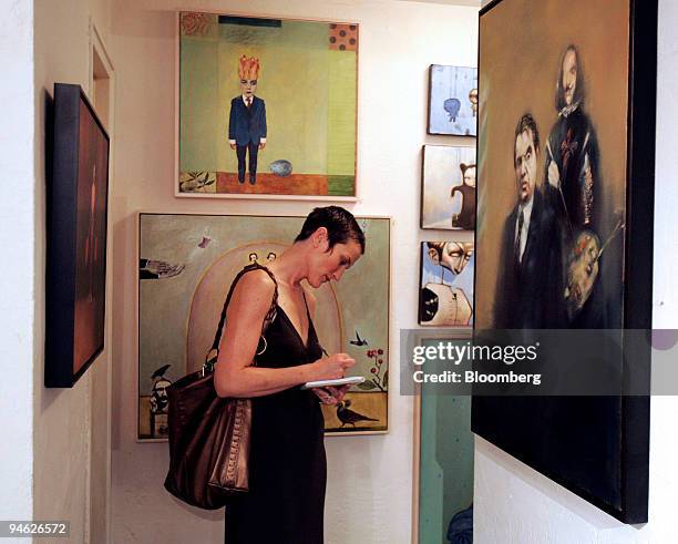 Tayloe White of Jacksonville, Florida, writes down information about artists in the Volakis Gallery as part of the Art Now fair at the Claremont...