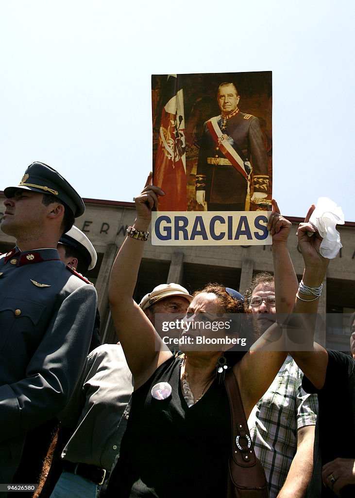 A woman holds a sign saying thanks to Chilean former dictato