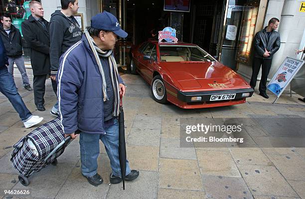 Pedestrians pass by James Bond's Lotus Esprit Turbo, driven by Roger Moore in the film, ``For Your Eyes Only,'' outside Planet Hollywood in London,...