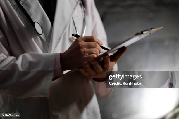 close up of doctor writing on chart - only mature men fotografías e imágenes de stock