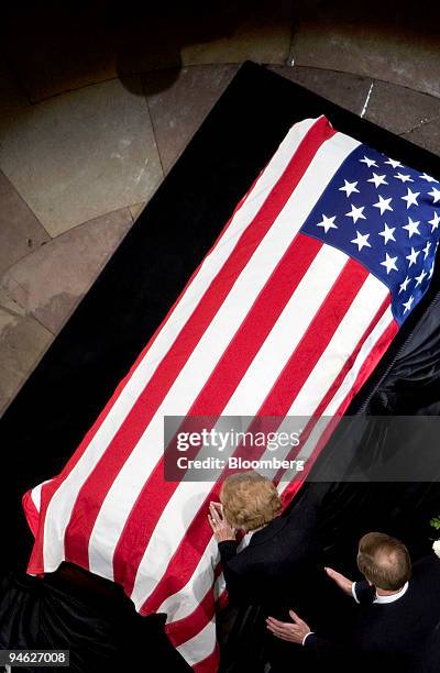 Former first lady Betty Ford, wife of former U.S. President Gerald Ford, places her hand on his casket while their son Jack Ford supports her during...