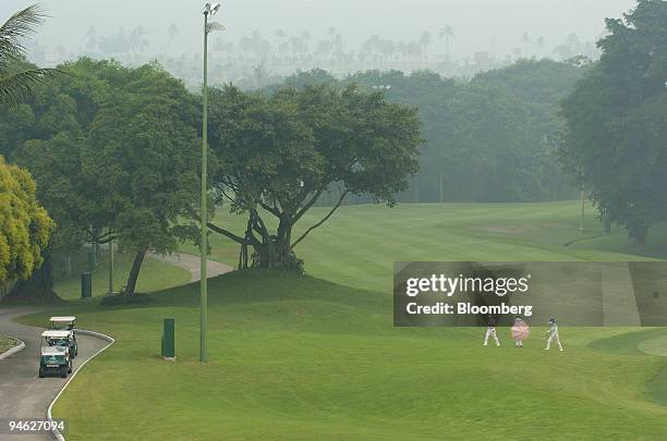 Three women golfers on the Sentosa Golf Club decide end their game after the course becomes blanketed by thick haze in Singapore on Monday, October...