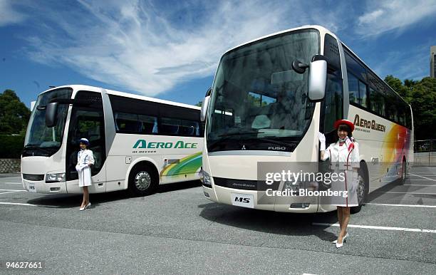 Models stand by Mitsubishi Fuso Truck & Bus Corp.'s Aero Queen Super Hi Decker Buses in Tokyo, Japan, on Friday, June 15, 2007. Mitsubishi Fuso Truck...