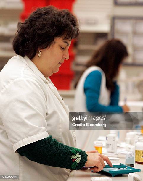 Pharmacist Grace Chiaro-Bolch, left and assistant Jean Galvin fill prescriptions at a Walgreens store in Willowbrook, Illinois, U.S., on Friday, Dec....