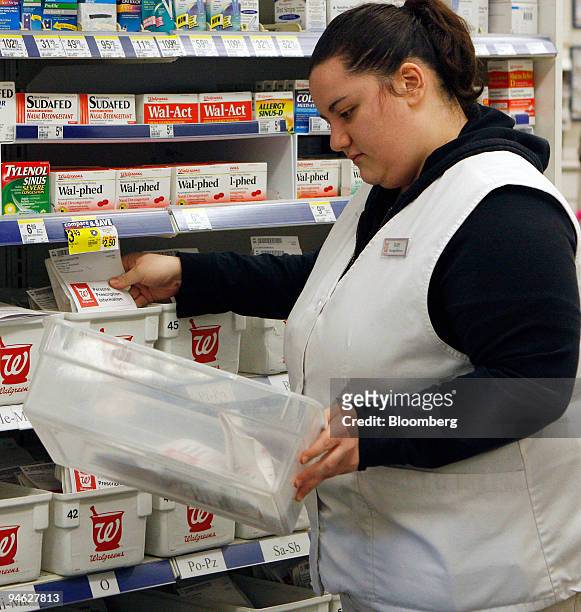 Pharmacy assistant Ruby Cardenas puts away filled prescriptions at a Walgreens store in Willowbrook, Illinois, U.S., on Friday, Dec. 21, 2007....