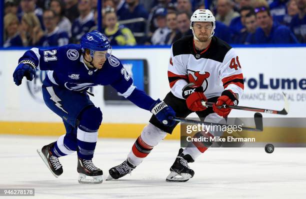 Brayden Point of the Tampa Bay Lightning and Michael Grabner of the New Jersey Devils fight for the puck during Game Two of the Eastern Conference...