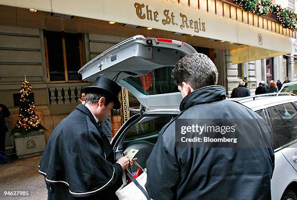 Doorman Pascal Conan, left, fills out a valet parking slip outside the St. Regis hotel, Thursday, December 28, 2006 in New York.