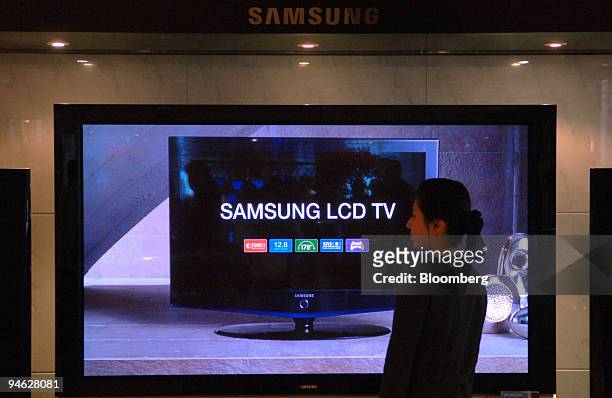 Samsung Electronics Co. Employee walks past front of LCD TV set at the company headquarters in Seoul, South Korea, Monday, October 16, 2006. Samsung...