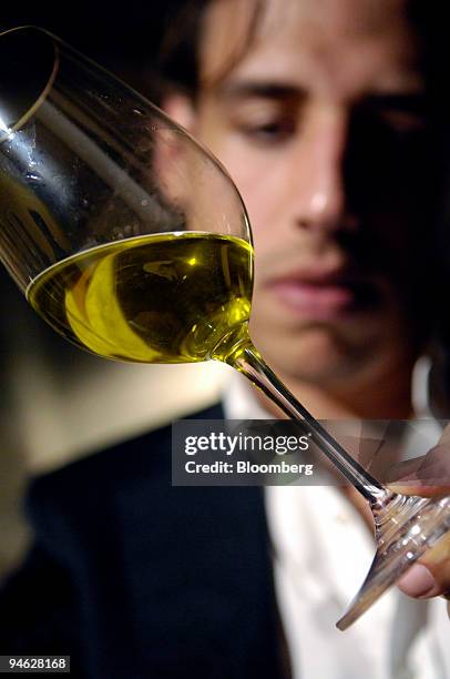 Di Bennardo, maker of Di Bennardo L'Olio d'Oliva, owner Giovanni Di Bennardo checks the color of olive oil at an olive oil tasting in a medieval wine...