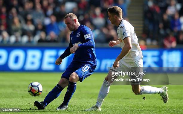 Wayne Rooney of Everton is challenged by Andy King of Swansea City during the Premier League match between Swansea City and Everton at Liberty...