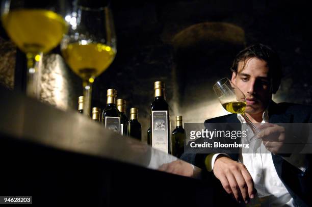 Di Bennardo, maker of Di Bennardo L'Olio d'Oliva, owner Giovanni Di Bennardo checks the color of olive oil at an olive oil tasting in a medieval wine...