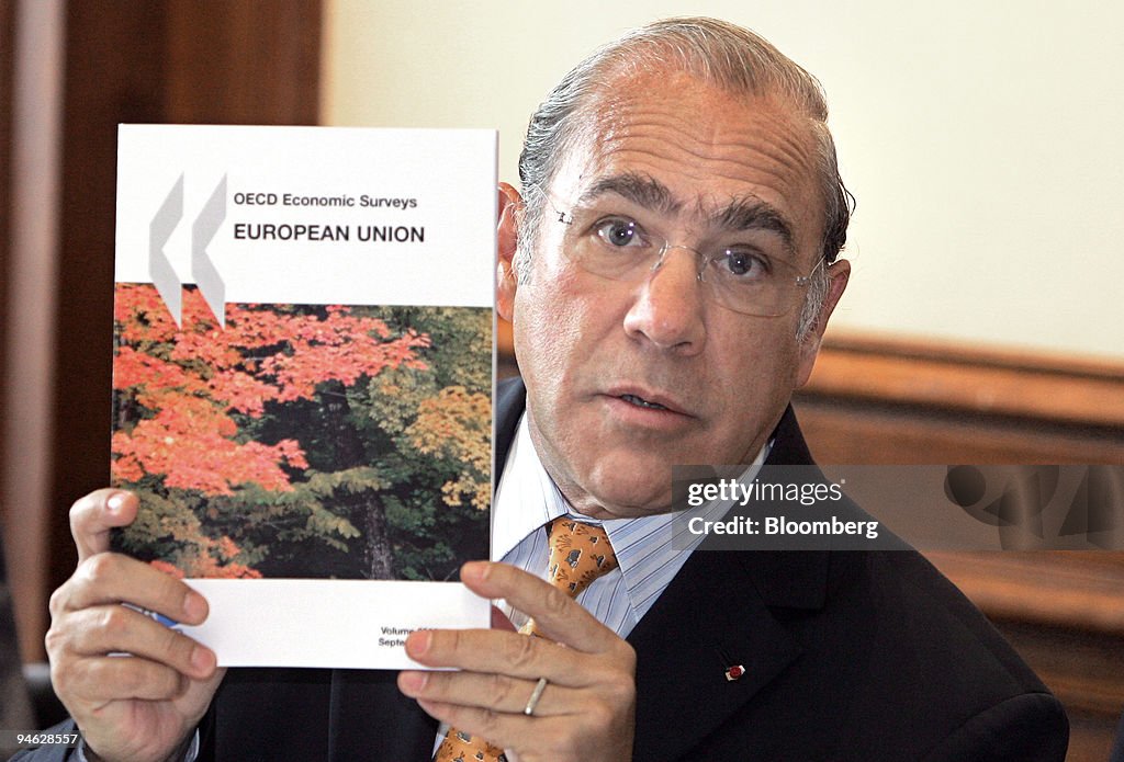 Angel Gurria, secretary-general of the OECD, shows the repor