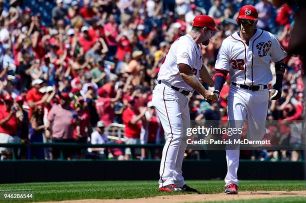 Matt Wieters of the Washington Nationals celebrates with third base coach Bob Henley as he rounds third base after hitting a solo home run in the...