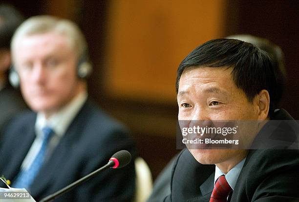 Fred Goodwin, chief executive officer of Royal Bank of Scotland Group Plc, left, looks on as Xiao Gang, chairman of the Bank of China Ltd., speaks...