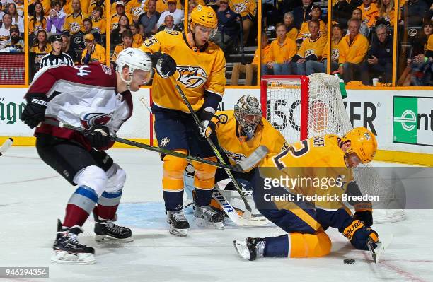 Carl Soderberg of the Colorado Avalanche and Pekka Rinne andAlexei Emelin of the Nashville Predators watch as Mike Fisher tries to control the puck...