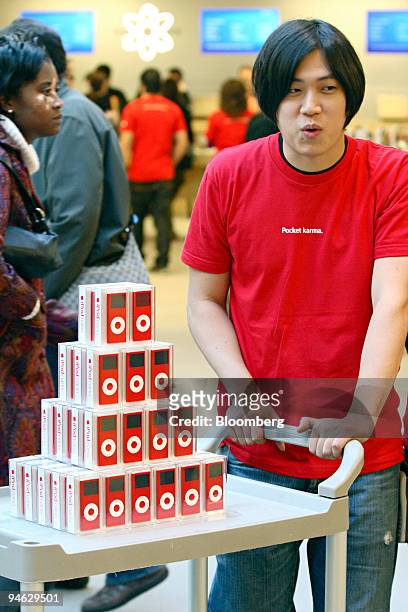 An Apple employee wheels in the new red iPod nano at the Fifth Avenue Apple store in New York City on Friday, October 13, 2006. Apple announced a new...