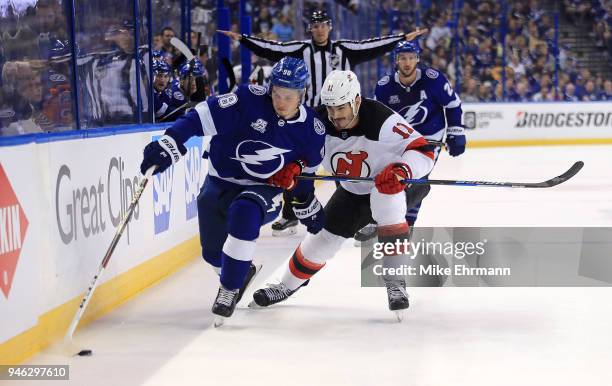 Mikhail Sergachev of the Tampa Bay Lightning and Brian Boyle of the New Jersey Devils fight for the puck during Game Two of the Eastern Conference...