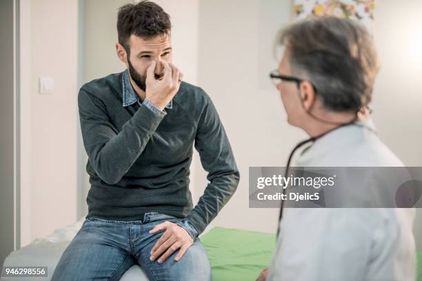 mid adult patient describing his breathing problem to a doctor. - nozes stock pictures, royalty-free photos & images