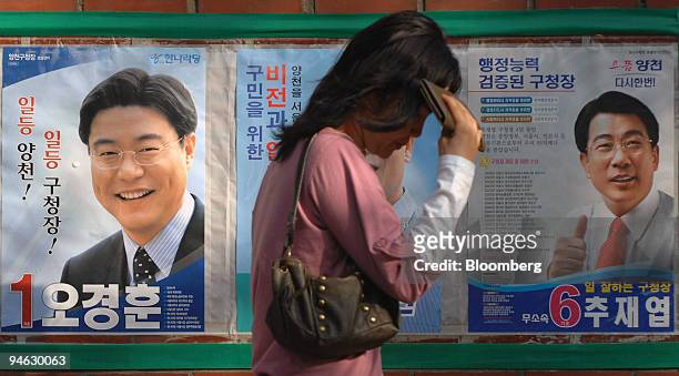 Pedestrian walks past a by-election candidate poster in Seoul, South Korea, on Wednesday, April 25, 2007. South Korea holds by-elections for three...
