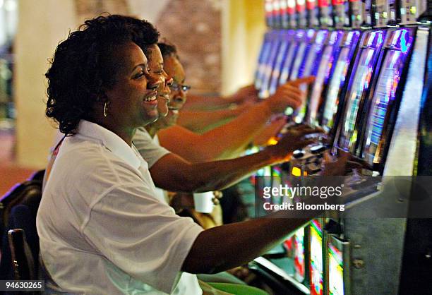 Sharon Johnson, foreground, her sister Andrea Bryant, center, and their friend Carol Peters play video gaming machines inside Harrah's New Orleans...