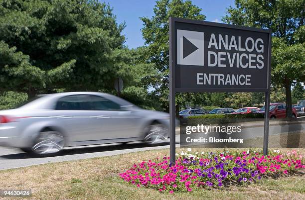 An Acura car passes by a sign at Analog Devices Inc.'s corporate headquarters in Norwood, Massachusetts, Friday, August 11, 2006. Shares of Analog...