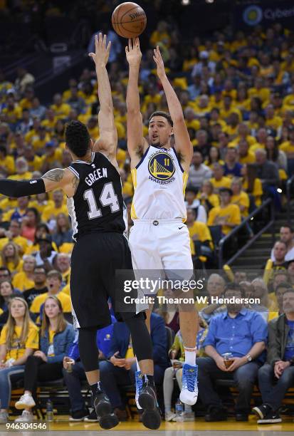 Klay Thompson of the Golden State Warriors shoots over Danny Green of the San Antonio Spurs in the third quarter during Game One of the first round...