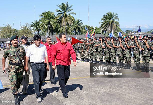 Bolivian President Evo Morales, left, in white shirt, and Venezuelan President Hugo Chavez, next to Morales in the red shirt, review a line of...
