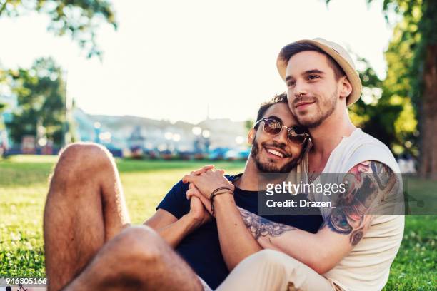 gay couple in park enjoying being together - beautiful gay men stock pictures, royalty-free photos & images