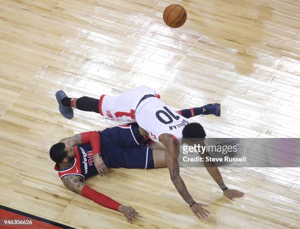 Toronto Raptors guard DeMar DeRozan collides with Washington Wizards forward Mike Scott as the Toronto Raptors open the first round of the NBA...