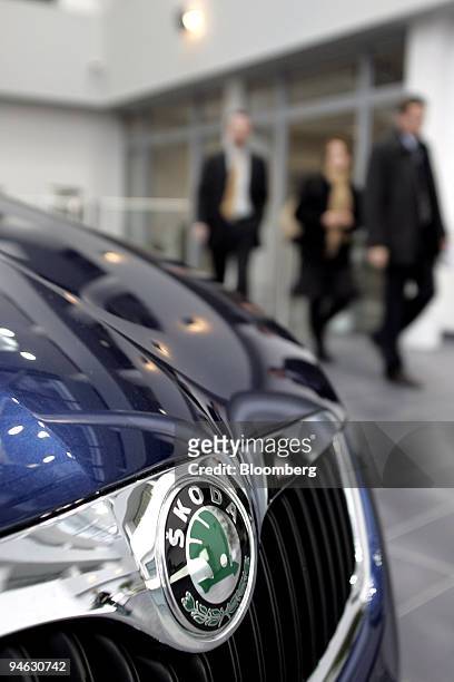 Skoda Auto S.A. Employees walk past a new car on display at the car maker's headquarters in Mlada Boleslav, Czech Republic, on Tuesday, December 12,...