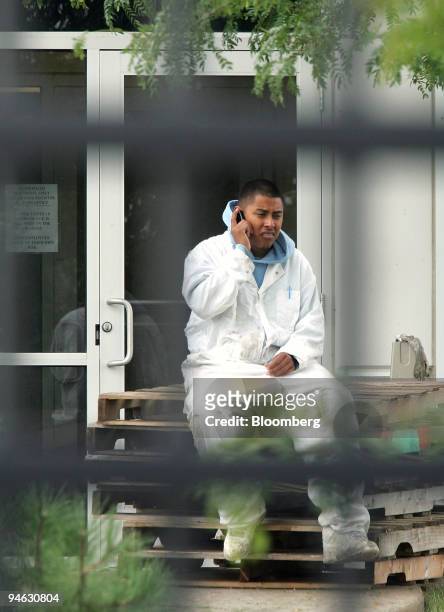 Visible through a security fence, a worker talks on his cell phone outside Cavel International Inc., a horse slaughterhouse in DeKalb, Illinois, on...