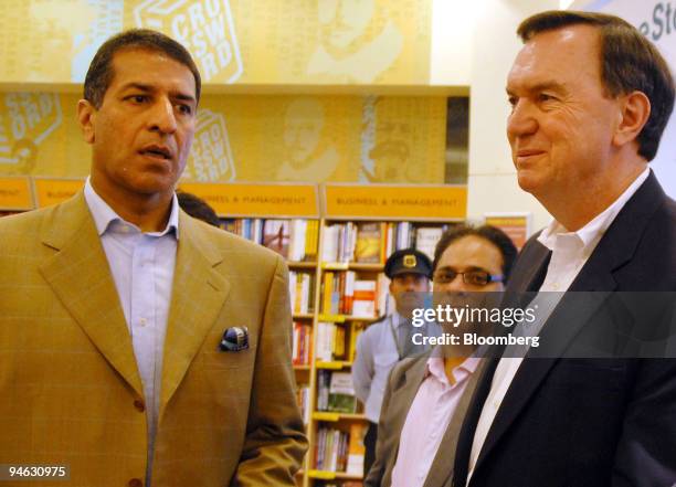 Wal-Mart's Vice Chairman Michael Duke, right, speaks with Bharti Group Joint Managing Director Rajan Mittal, left, during a tour of the Inorbit Mall...